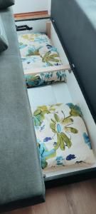 two twin beds in a bunk room with flowers at AMRAI Karamella in Ventspils