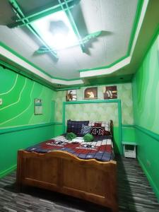 - une chambre avec un lit aux murs verts dans l'établissement Cubao Quezon city Transient condo unit, à Manille