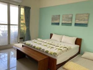 東港的住宿－風宿-環島東港站 ，一间卧室设有一张大床和一个窗户。