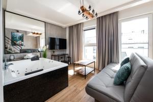 salon z dużą wanną i kanapą w obiekcie Relaxroom Szmaragd w Redzie