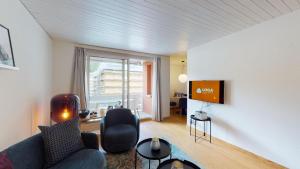 un soggiorno con divano e TV di Abitaziun Skyline 414 - St Moritz "LOGA ELEGANCE APARTMENT" a Sankt Moritz