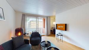 a living room with a couch and a tv at Abitaziun Skyline 414 - St Moritz "LOGA ELEGANCE APARTMENT" in St. Moritz