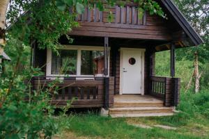 a small cabin with a porch and a white door at Abisko Mountain Lodge in Abisko