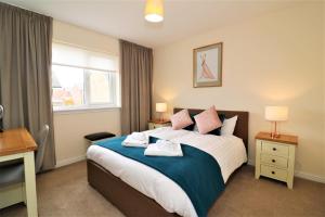 a bedroom with a bed and a desk and a window at Signature - Morrison House in Glasgow