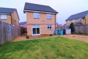 a brick house with a fence and a yard at Signature - Morrison House in Glasgow