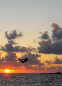 a person in the air over the ocean at sunset at Al Vecchio Pontile bed and breakfast in Marsala