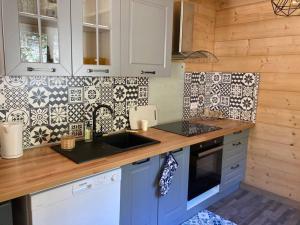 cocina con armarios azules y encimera en Forest Jura Lodge - Chalet des sapins, en Alièze