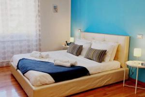 um quarto com uma cama grande e toalhas em Blue Apartment em Cagliari