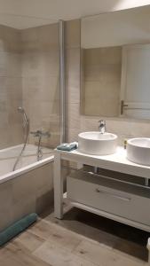 a bathroom with two sinks and a tub and a mirror at SOUS LE NEFLIER in Nîmes