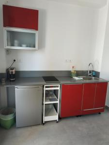 a kitchen with red cabinets and a sink at Enalion residences in Tinos