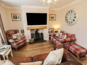 a living room with couches and a flat screen tv at Lavender Cottage in Saltburn-by-the-Sea
