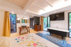 una camera con un grande letto e una vasca da bagno di Etna Botanic Garden a Mascalucia