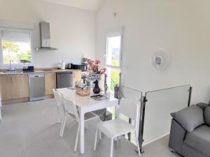 a kitchen and dining room with a white table and chairs at Raio do Sol - Apartamento Turístico in Muxia