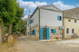 un antiguo edificio de piedra con persianas azules en una calle en Casa Giorgio, en Poreč