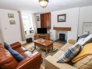 a living room with a couch and a coffee table at Royal Oak Cottage in Amlwch