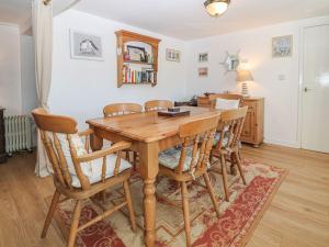 a dining room with a wooden table and chairs at Royal Oak Cottage in Amlwch