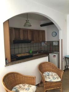 una cucina con 2 sedie in vimini e un bancone di La Terrazza sul Mare a Sellia Marina