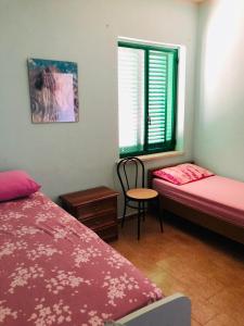 sypialnia z 2 łóżkami, oknem i krzesłem w obiekcie La Terrazza sul Mare w mieście Sellia Marina