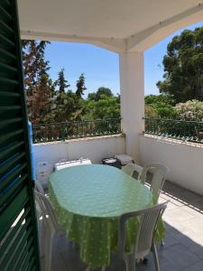a green table and chairs on a balcony at La Terrazza sul Mare in Sellia Marina