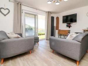 a living room with two couches and a tv at Waves in Woolacombe