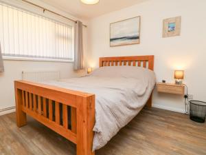 a bedroom with a wooden bed and a window at Waves in Woolacombe