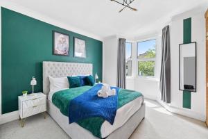 a green and white bedroom with a bed and a window at Comfortable 2 Bedroom Flat Overlooking the park in Bristol