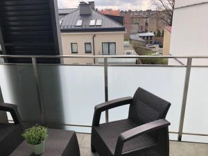 einen Balkon mit 2 Stühlen und einem Tisch in der Unterkunft ApartamentySnu, Jagielloński Komfort, Centrum in Radom