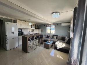 een keuken en een woonkamer met een bank en een fornuis bij Sunsetview Beach Apartment in Palmyre