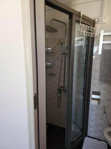 a bathroom with a shower with a glass door at Sunsetview Beach Apartment in Palmyre +23 photos