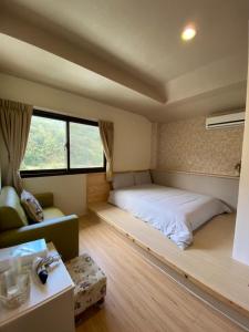 a bedroom with a bed and a couch and a window at Fu Chuan Garden in Nanzhuang