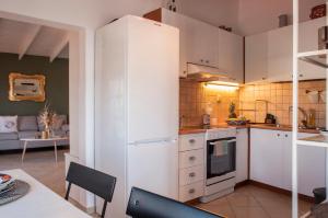 a kitchen with a white refrigerator and a table at Adorable Country House with sea & church view! in Kokkíni Khánion