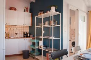 a kitchen with a shelf with dishes on it at Adorable Country House with sea & church view! in Kokkíni Khánion