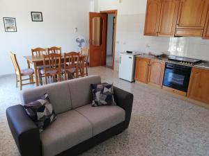 a living room with a couch and a kitchen at Appartamento da Anna in Falcone