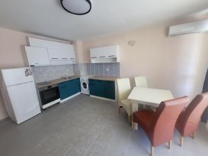 a kitchen with blue cabinets and a table and chairs at Lucky Sun Kranevo Apartments in Kranevo