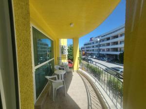 a balcony with chairs and a table and a building at Lucky Sun Kranevo Apartments in Kranevo