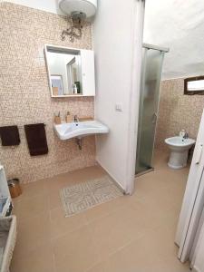 een badkamer met een wastafel, een toilet en een spiegel bij Corte Sirio Rooms & Apartment in Sannicola