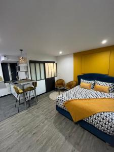 Cet appartement comprend une chambre avec un lit, une cuisine et une table. dans l'établissement Privilège Spa, jacuzzi & Sauna, 