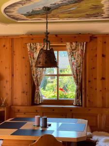 ミッテンヴァルトにあるFerienwohnungen Janaのテーブルと窓のあるダイニングルーム +8枚の写真