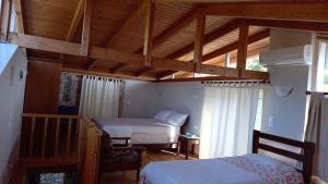 a bedroom with two beds and a wooden ceiling at Kassi's House in Marantochori