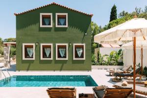 una casa verde con piscina e sedie di Stavlos Luxury Stone House a Ialyssos