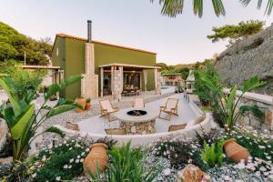 un giardino con tavolo e sedie e un edificio di Stavlos Luxury Stone House a Ialyssos