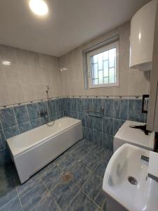 a bathroom with a tub and a sink at Apartmani Tarsko Jezero Nova Vezanja in Zaovine