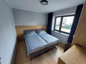 a small bedroom with a bed and a window at Turystyka 4jeziora Iława in Iława