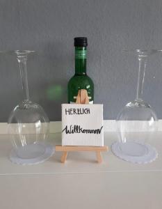 a bottle of wine sitting on a shelf with two wine glasses at Traumwohnung 5 Min zum Bike Park in Willingen