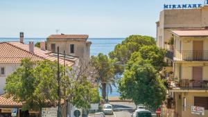 a city street with buildings and the ocean in the background at Casa Corallina, wi-fi air-con IUN Q7749 in Cala Gonone
