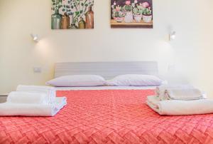 two beds with white towels on a red carpet at Casa Corallina, wi-fi air-con IUN Q7749 in Cala Gonone