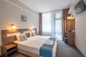 Säng eller sängar i ett rum på Park Hotel Asenevtsi