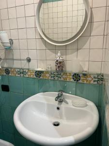 een badkamer met een witte wastafel en een spiegel bij Casa Rosaria in Vietri
