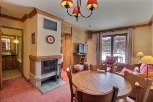 - un salon avec une table et une cheminée dans l'établissement ARC 1950 - Suite de Prestige - Cheminée intérieur, à Arc 1950