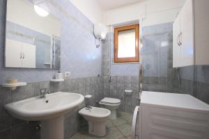 a white bathroom with a sink and a toilet at Villa Il Melograno in Tortolì +43 photos